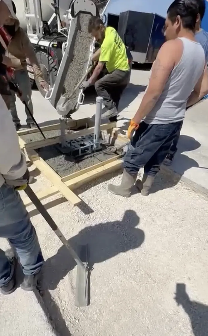 Concrete being placed around conduits for an EV charging equipment foundation