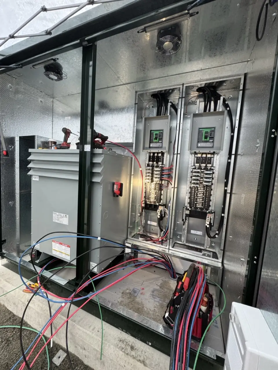 Transformer and electrical distribution panels open during testing and commissioning
