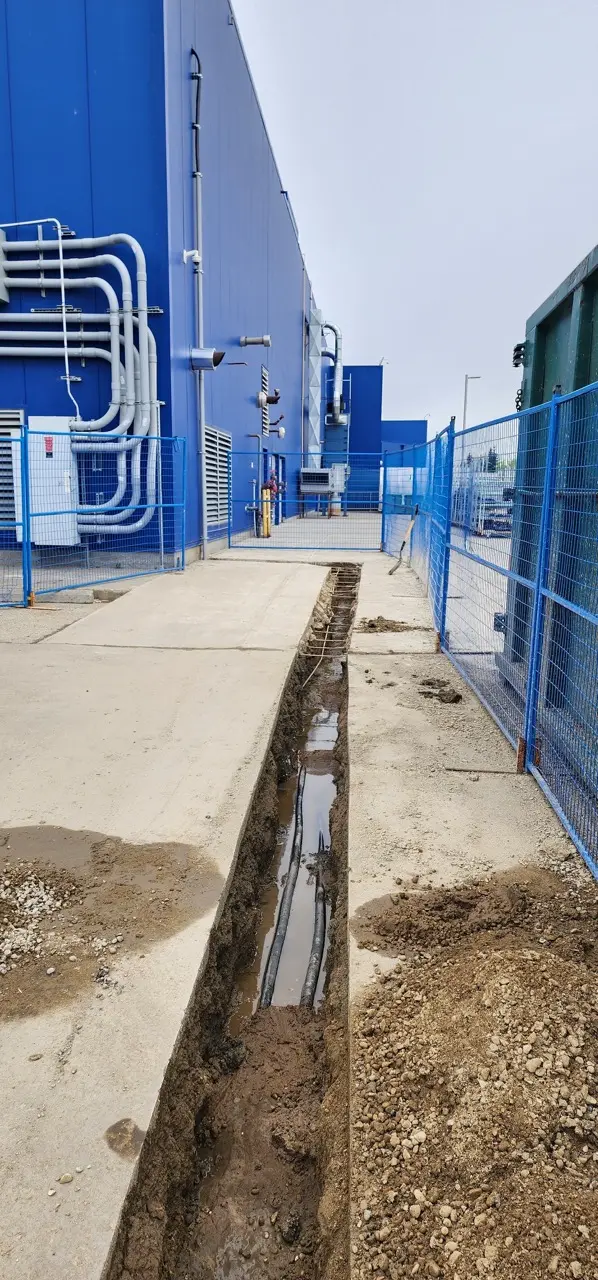 Long electrical trench cut through an operating commercial site