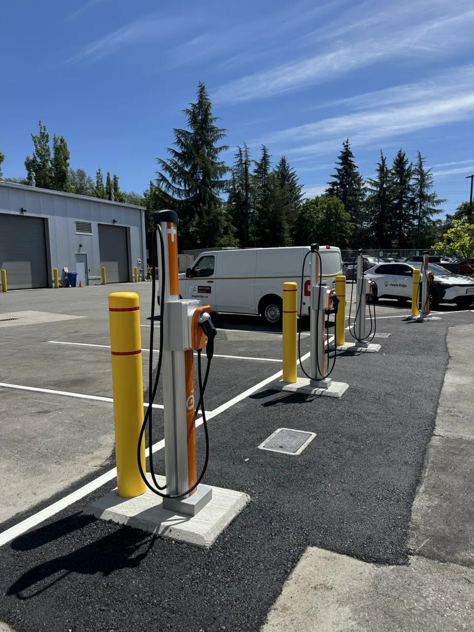 ChargePoint Level 2 charging pedestals protected by yellow bollards at Maple Ridge